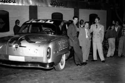 Hombres junto a auto de carreras, retrato de grupo