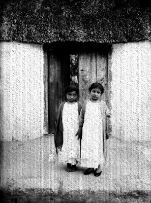Niñas indígenas fuera de una vivienda, retrato