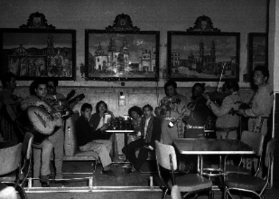Mariachi cantando a personas en una cantina