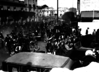 Charles Lindbergh, Dwight Morrow y otras personas en un automóvil escoltado por militares por una calle de la Cd. de México