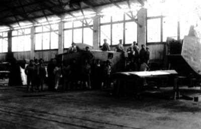 Mecánicos junto a partes de avión en un taller, retrato de grupo