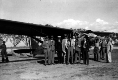 Carlos Castillo Bretón y otros hombres junto a un avión, retrato de grupo