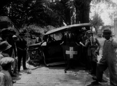 Personas junto un automóvil accidentado