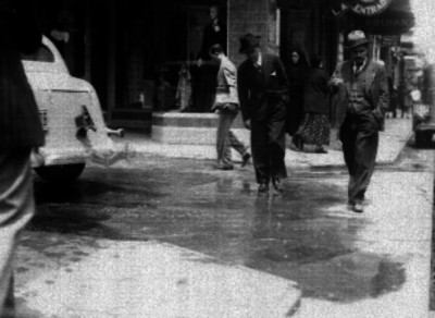 Gente cruzando una calle despúes de una inundación