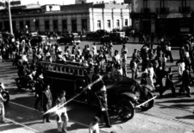 Carro de bomberos transportando un féretro por una calle