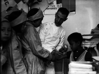 Médico auxiliado por enfermeras, aplicando vacunas