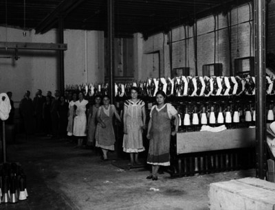 Obreras junto a maquinaría en una fábrica de hilados