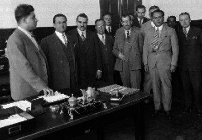 Comandante Meneses Ríos y Frías acompañados de otros hombres en una reunión, retrato