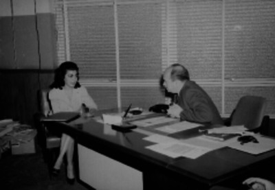 Empresario del periódico Novedades conversando con una mujer