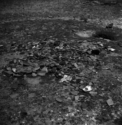 Restos de alfarería prehispánica y osamentas en la superficie de una zona arqueológica