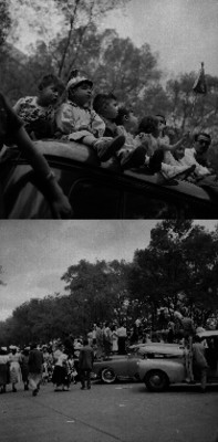 Niños sobre un auto tipo combi observando un desfile en un parque