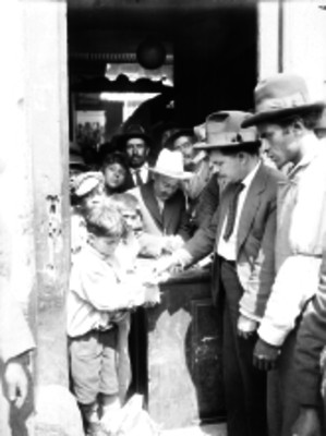 Manuel Cochardo comprando periódico a unos voceadores