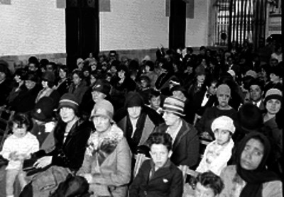 Hombres y mujeres en un salón durante una asamblea