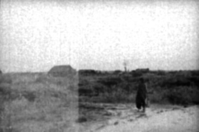 Mujer de condición humilde caminando por el campo