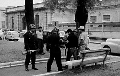 Granaderos conduciendo a indocumentados por una calle