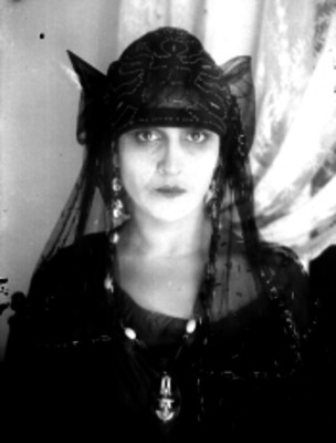 Gitana con un atuendo típico y un dije en el cuello, retrato