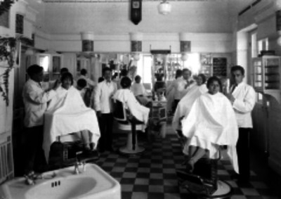 Empleados peluqueros cortando el pelo a clientas en el interior de un salón de belleza, retrato