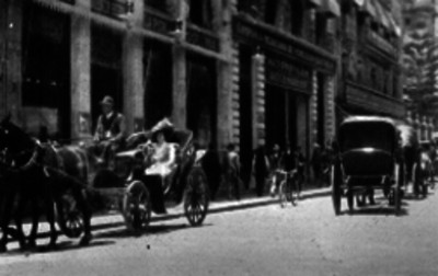 Mujer en un carruaje paseando por una calle de la Ciudad de México