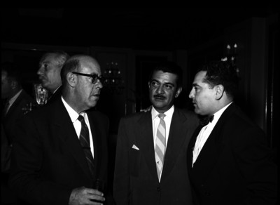 Hugo Aguilar conversa con otros individuos durante un evento social