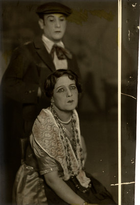 Mimí Aguglia sentada junto a un actor en una representación teatral, retrato