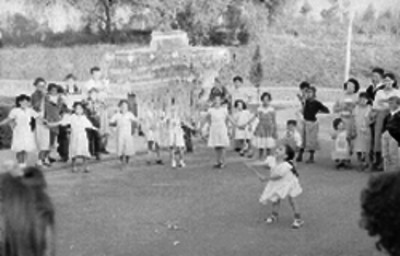 Personas mayores y niños tratando de romper una piñata en el patio de una casa