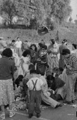Personas rompiendo una piñata durante una posada