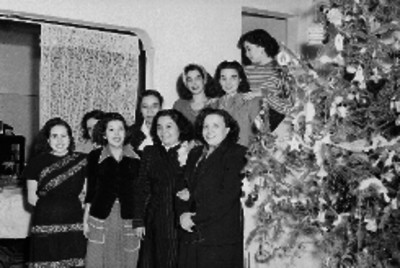 Mujeres de pie junto a un árbol de navidad, retrato