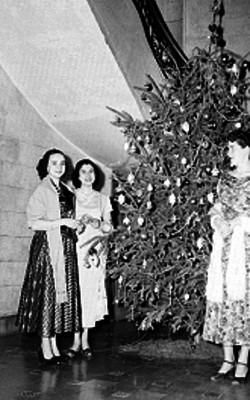 Mujeres de clase media con rebozo junto a un árbol de navidad, retrato