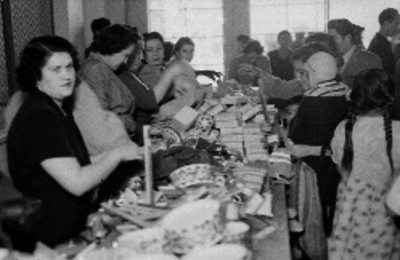 Mujeres de clase alta repartiendo obsequios a la gente pobre
