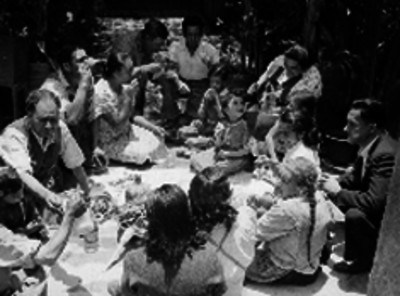 Hombres comiendo chicharrón en un patio