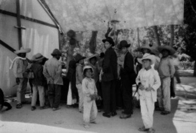 Campesinos observando en un local de juegos de azar en un parque