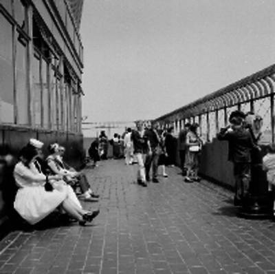 Turistas observando el edificio más alto del mundo y mujeres sentadas en unas bancas