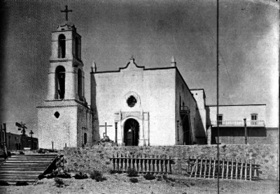 Entrada y torre con campanario de una iglesia