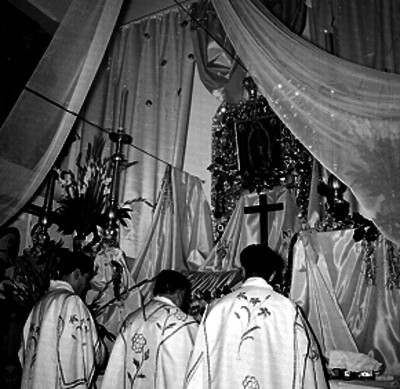 Sacerdotes dentro de iglesia dirigidos hacia el altar