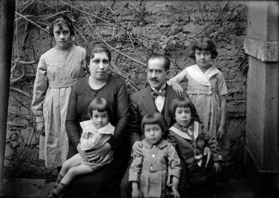 Miembros de una familia en el patio de una casa, retrato