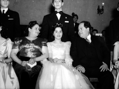 Agustín Arroyo Ch. con su esposa e hija durante un evento social en un salón