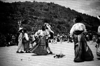 Parejas con trajes Zapotecas ejecutan un baile en la Guelaguetza