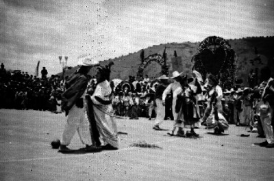 Parejas ataviadas con trajes Zapotecas al ejecutar un baile en la Guelaguetza