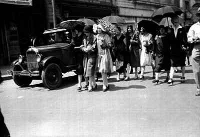 Mujeres con sombrillas caminan por la calle