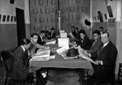 Hombres en una biblioteca de revistas castellanas