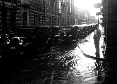 Automóviles transitando por una calle inundada