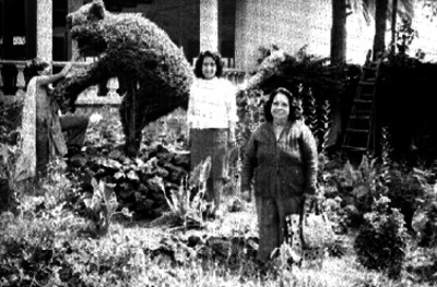 Mujeres junto a arbustos con formas de animales, retrato