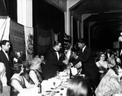 Hombre entregando un trofeo durante un banquete en un salón