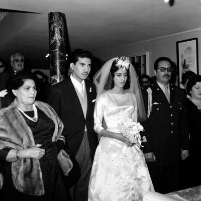 Novios celebran su matrimonio civil, acompañados de sus padres y familiares en una habitación