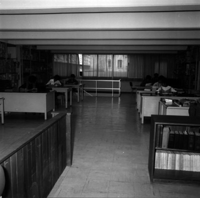 Vista parcial de una biblioteca con personas en escritorios