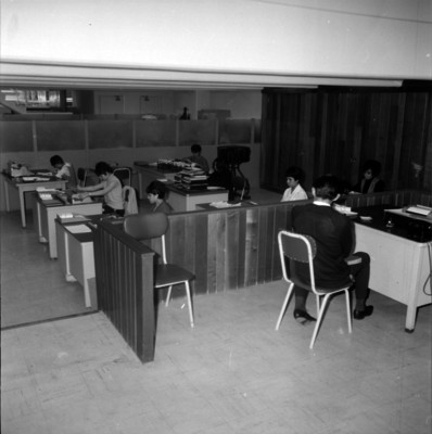 Secretarias trabajan en escritorios, vista parcial de una oficina