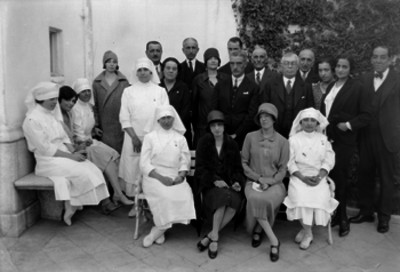 Integrantes de la cruz roja española y demás personas en un patio, retrato de grupo