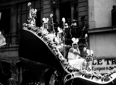 Carro alegórico en forma de zapatilla con mujeres disfrazadas durante un carnaval