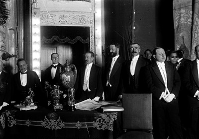 Hombres elegantes en un salón muy decorado, retrato de grupo