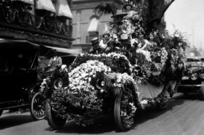 Gente con trajes regionales en un carro alegórico, durante un desfile